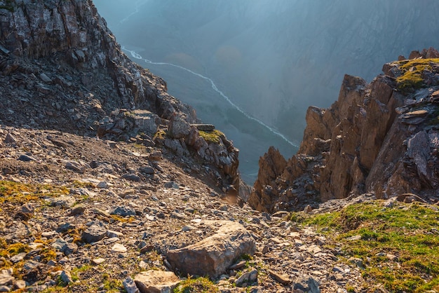 Ehrfürchtiger Blick auf die Berge von der Klippe in sehr großer Höhe Malerische Landschaft mit schönen scharfen Felsen in der Nähe von Abgrund und Couloirs im Sonnenlicht Schöne Berglandschaft am Rand des Abgrunds mit scharfen Steinen