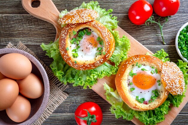 Ei gebacken in einem weichen Brötchen mit frischen Kräutern des Schinkens Köstliches und schnelles Frühstück Draufsicht