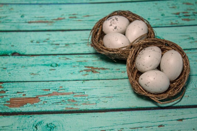 Ei im Nest auf blauem Holzhintergrund