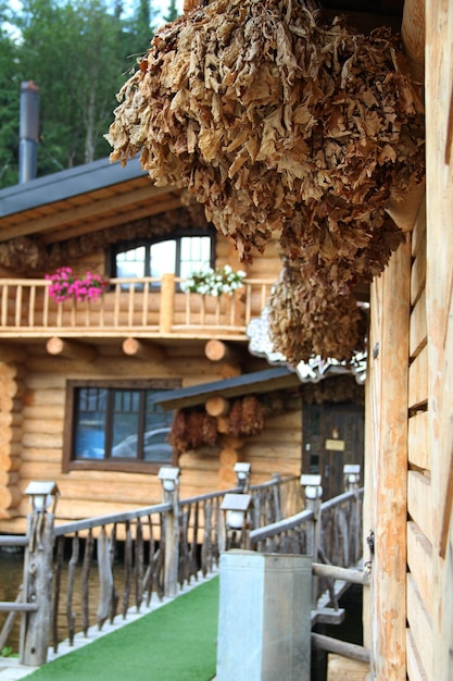 Eichenbesen für Dampfbad hängt an einer Holzwand der Blocksauna