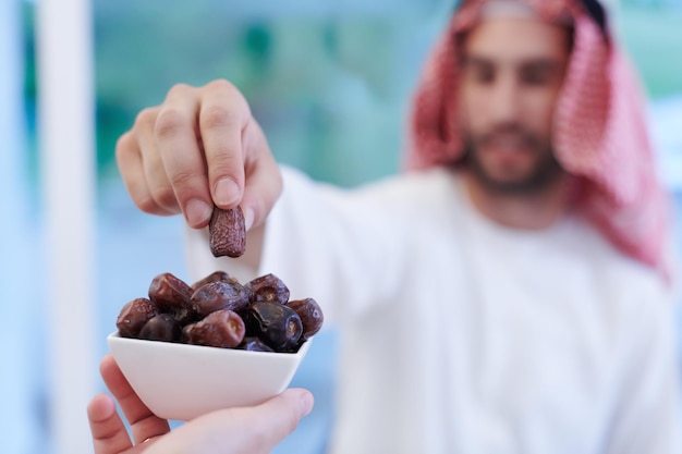 Eid Mubarak Familia musulmana cenando Iftar comiendo dátiles para romper la fiesta. Comer comida tradicional durante el mes de fiesta del Ramadán en casa. La comida y bebida halal islámica en el Islam occidental moderno