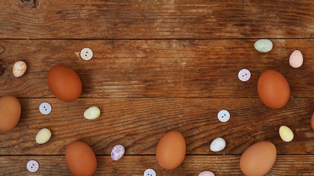 Eier auf einem hölzernen rustikalen Hintergrund mit Kopienraum für Text. Frische Hühnereier und dekorative Eier für die Osterdekoration.