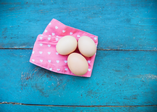 Eier auf Tischdecke über Holzoberfläche