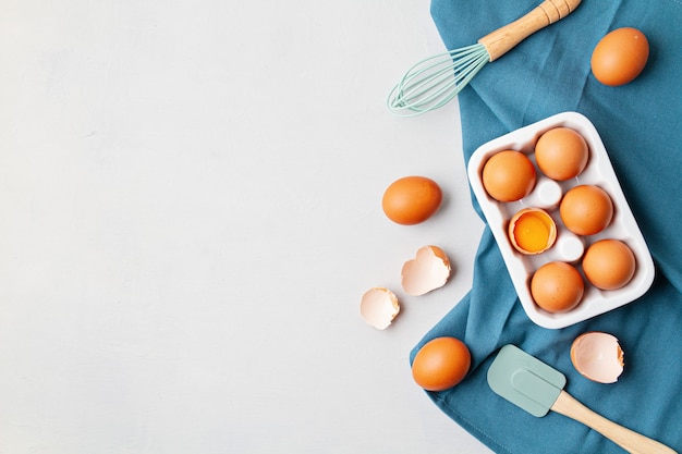 Eier, Handtuch im rustikalen Stil auf heller Wand. Bio-Zutat, gesundes Lebensmittel-Lifestyle-Konzept. Osterwand. Flache Lage, Kopierraum. Rustikale Tischoberansicht.