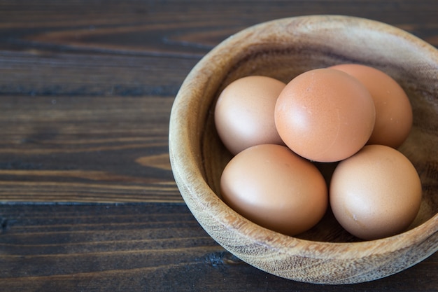 Eier im hölzernen Schüsselhintergrund