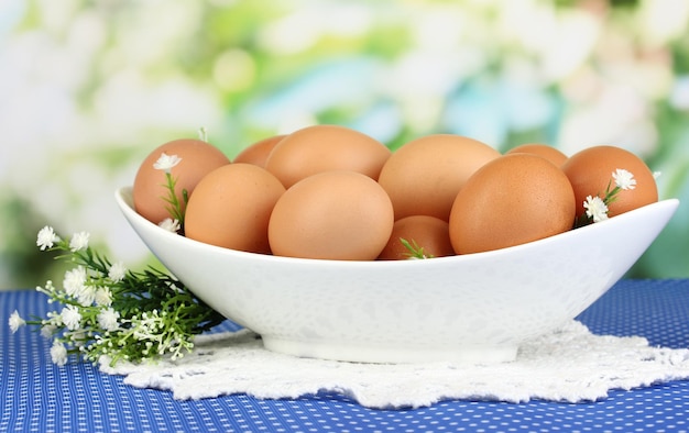 Eier in weißer Schüssel auf blauer Tischdecke Nahaufnahme