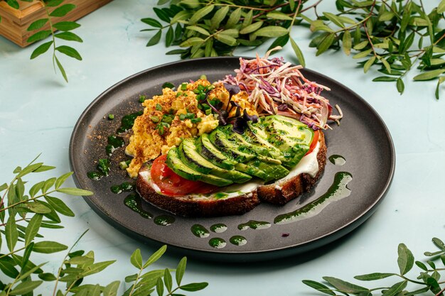 Eier rühren mit Avocado-Sandwich und Salat