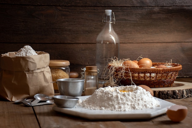 Eier, Teig und Mehl auf Holztisch mit splat Hintergrund für einen Gegenstand in einer Bäckerei