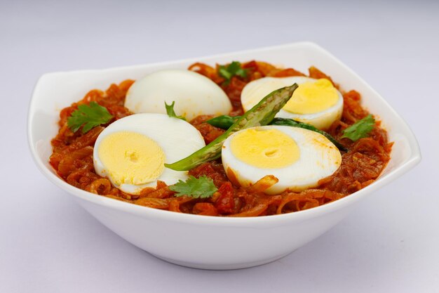Eierbraten oder indischer Eier-Masala-Curry, würziger roter Eierbraten, angeordnet in einer weißen Keramikschale