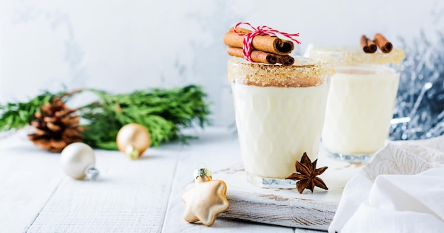 Eierlikör Traditionelles Weihnachtsgetränk Milchshake mit Zimt auf hellem alten Hintergrund. Selektiver Fokus.