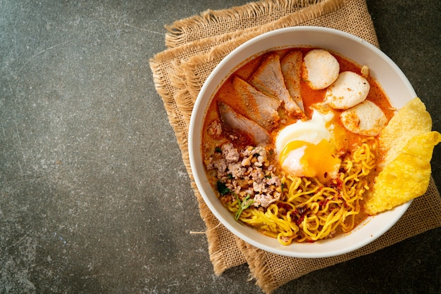 Eiernudeln mit Schweinefleisch und Frikadellen in scharfer Suppe oder Tom Yum Nudeln nach asiatischer Art