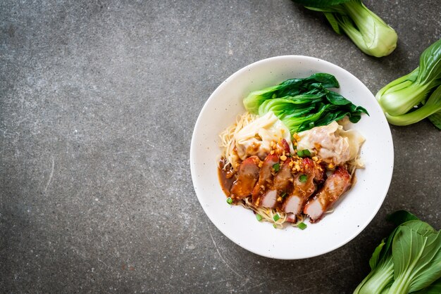 Eiernudelsuppe mit knusprigem Schweinebauch und Wonton. Asiatischer Essensstil