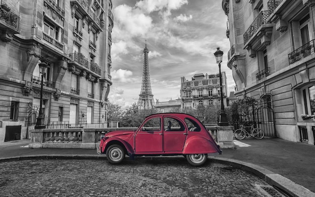 Eiffelturm in Paris und rotes Retro-Auto in Schwarz-Weiß-Farbschlüssel