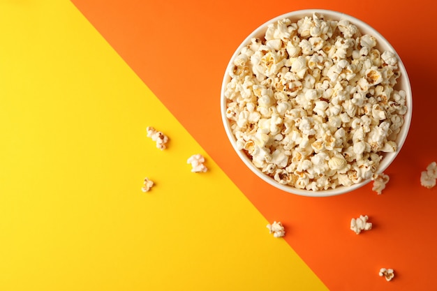 Eimer mit Popcorn auf zweifarbigem Hintergrund