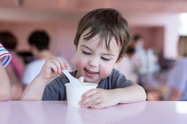 Ein 34-jähriger Junge isst Eis in einem Café Closeup Portrait Sommer in der Hitze der Stadt