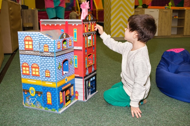 Ein 4-jähriger Junge spielt im Spielzimmer des Kinderunterhaltungszentrums mit einem großen Spielzeugschloss