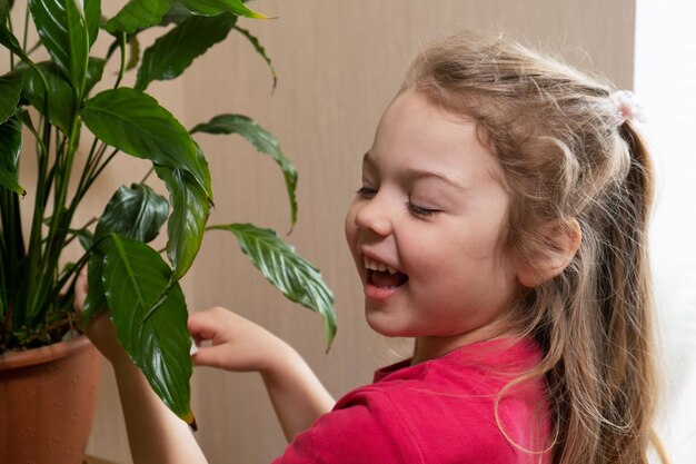 Foto ein 4-jähriges mädchen kümmert sich um heimische pflanzen heimbepflanzung aus dem kindheitskonzept