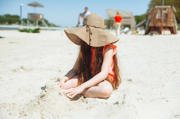 Ein 7-jähriges Mädchen spielt im Sand an einem Stadtstrand Urlaub und Erholung Verspieltes aktives Kind am Strand in den Sommerferien