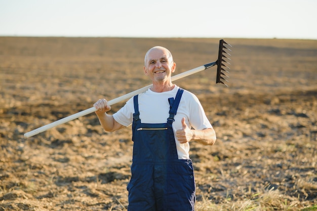 Ein älterer Bauer arbeitet auf einem Feld mit Erde