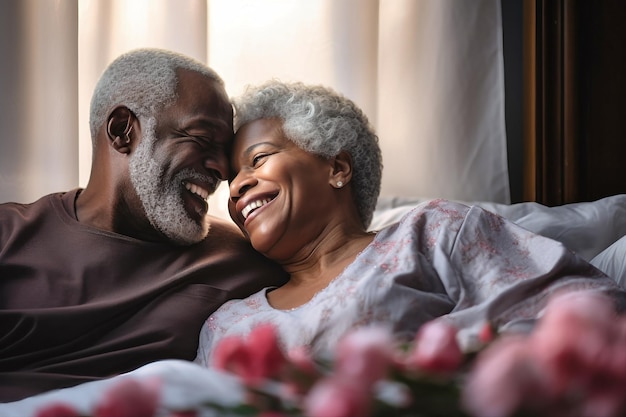 Ein älterer dunkelhäutiger Mann und eine ältere dunkelhautige Frau umarmen sich liebevoll, während sie sich auf einem Bett kuscheln, um Liebe und Romantik in ihrer Beziehung zu zeigen