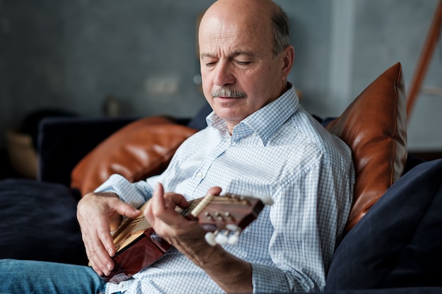 Ein älterer Mann lernt Gitarre zu spielen