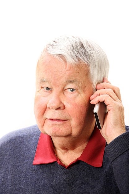 ein älterer Mann telefoniert vor weißem Hintergrund