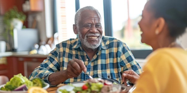 Ein älterer Mann und seine Pflegeperson genießen zu Hause eine gemeinsame Mahlzeit