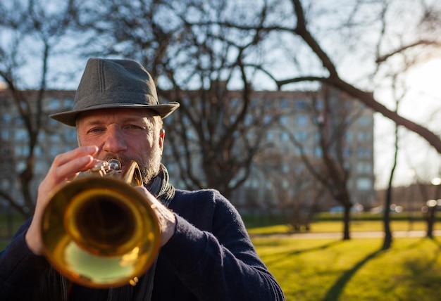 Foto ein älterer musiker spielt im frühling auf der straße auf einer trompete