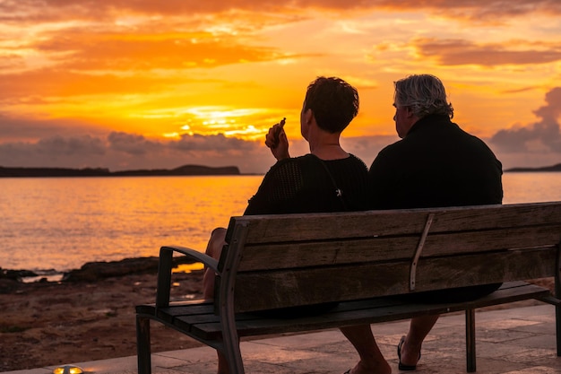 Ein älteres Ehepaar an der Promenade bei Sonnenuntergang auf der Insel San Antonio Abad Ibiza