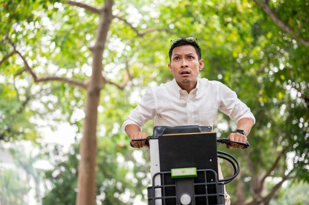 Foto ein ängstlicher asiatischer geschäftsmann ist in eile, morgens mit dem fahrrad zur arbeit zu kommen