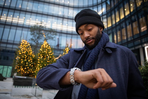 Ein afrikanischer Geschäftsmann überprüft an einem Wintertag die Zeit von seiner Uhr