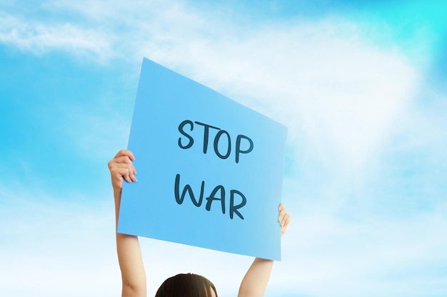 Foto ein aktivist hält ein transparent mit der aufschrift stop war