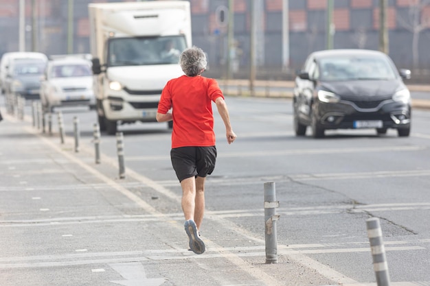 Ein alter Mann, der auf der Straße joggt