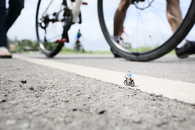 Ein alter Mann Miniatur auf Radtour in Landstraße mit einer Gruppe von Radrennen Hintergrund