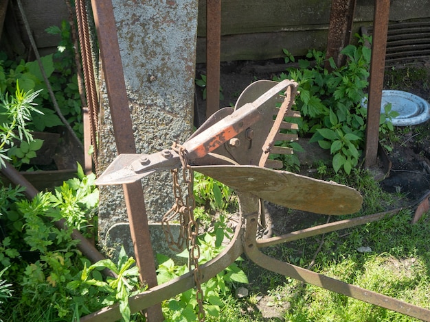 Ein alter rostiger Pflug liegt an einem sonnigen Sommertag im Gras