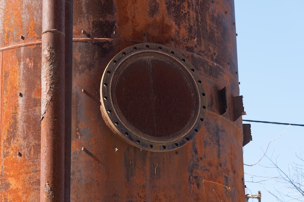 Ein alter rostiger Wasserturm aus Metall Alte Produktionstechnologie, die Trocknung im agroindustriellen Komplex verarbeitet Rotes Silo auf dem Himmelshintergrund Metallkonstruktion
