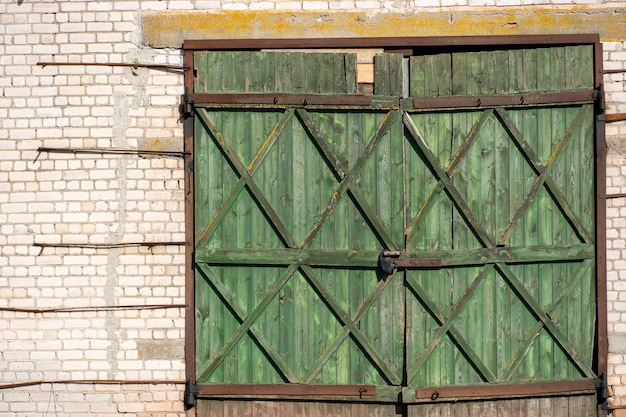 Ein altes Backsteingebäude mit einem großen Holztor Eine Kolchose oder Scheune im russischen Hinterland