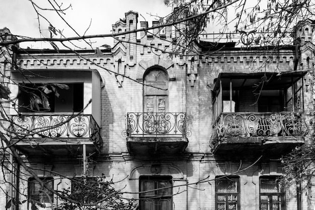 Ein altes elegantes verfallenes Herrenhaus. Restaurierung und Reparatur. Vorderansicht. Schwarzweißfoto.