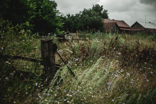 Ein altes verlassenes Grundstück im Dorf Rotten Zaunbau vor dem Hintergrund alter Häuser