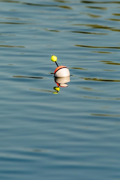 Ein Angelschwimmer schwimmt auf dem Wasser des Sees und macht Kreise im Wasser
