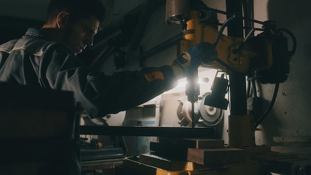 Ein Arbeiter arbeitet an einer Metallbohrmaschine in einer Werkstatt