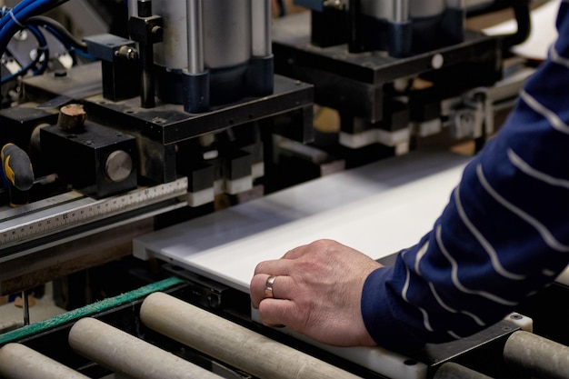 Foto ein arbeiter bearbeitet in einer fabrik möbelrohlinge auf einer werkzeugmaschine. industrielle herstellung von möbeln.