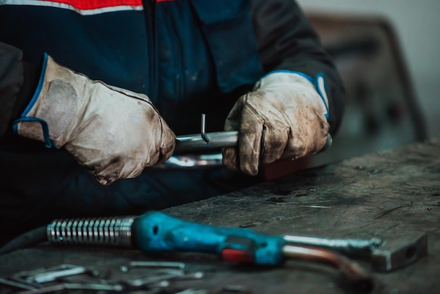 Ein Arbeiter in einer Industrie, der Eisenkonstruktionen zum Schweißen vorbereitet