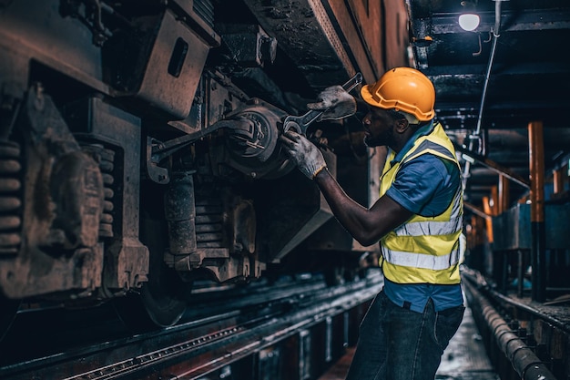 Ein Arbeiter repariert defekte Teile eines alten Zuges in Reparaturwerkstätten für Diesellokomotiven