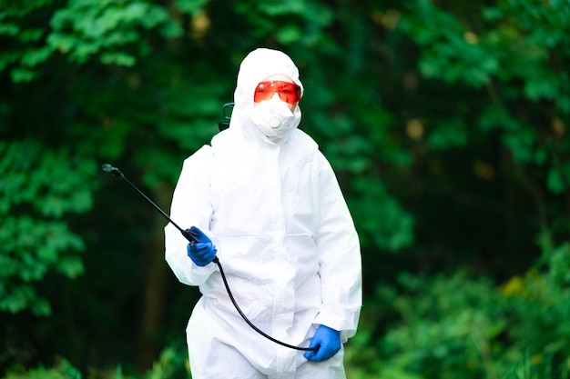 Foto ein arbeiter sprüht pestizide auf bäume im freien baumbekämpfung insektenbekämpfung