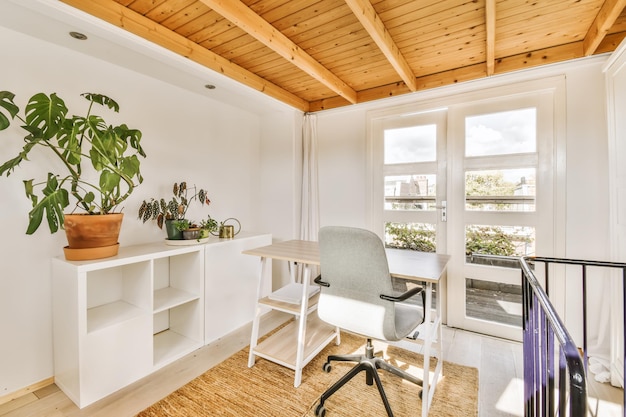 Ein Arbeitszimmer mit weißen Wänden und einer Holzdecke