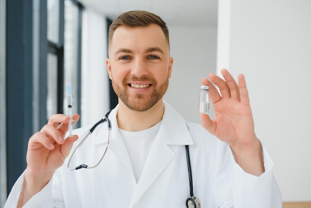 Ein Arzt in blauen Handschuhen, der eine Flasche mit Impfstoff hält Nahaufnahme Medizin- und Gesundheitskonzept