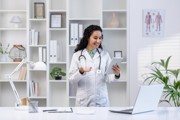 Ein Arzt in der medizinischen Kanzlei steht mit einem Tablet-Computer in der Hand, ein Klinikarbeiter in Weiß
