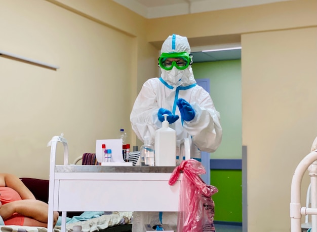Ein Arzt in einem Anti-Pest-Anzug nimmt Bluttests von einem Patienten mit einem Coronavirus ab
