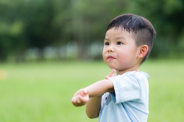 Ein asiatischer Junge kratzt sich am Arm